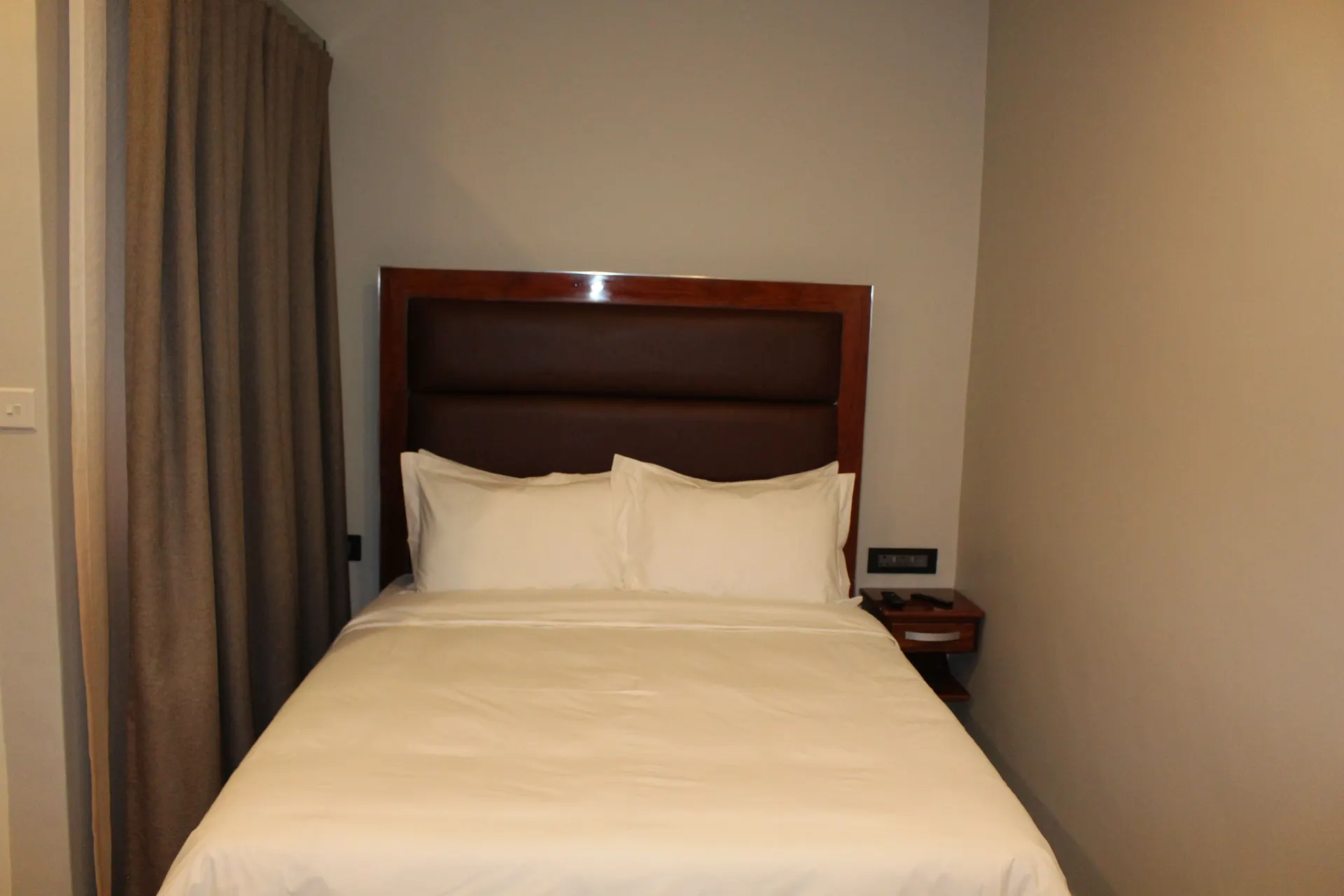 Compact Basic Room at FIRN Lodge with a double bed, two pillows and a floating bedside drawer