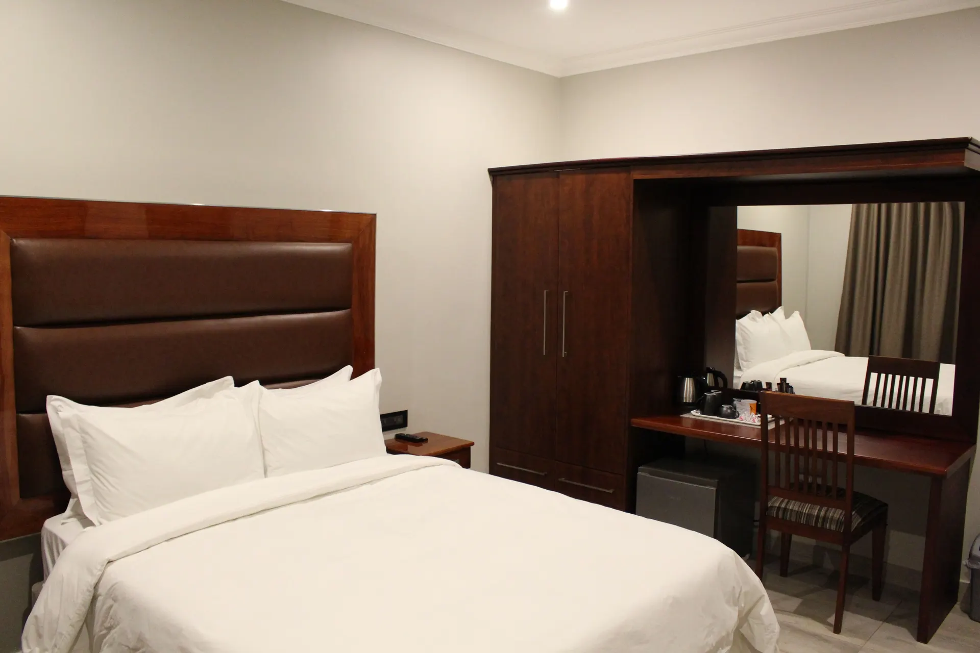Deluxe Room at FIRN Lodge with a queen bed and a built-in wardrobe, mirror and desk with tea station