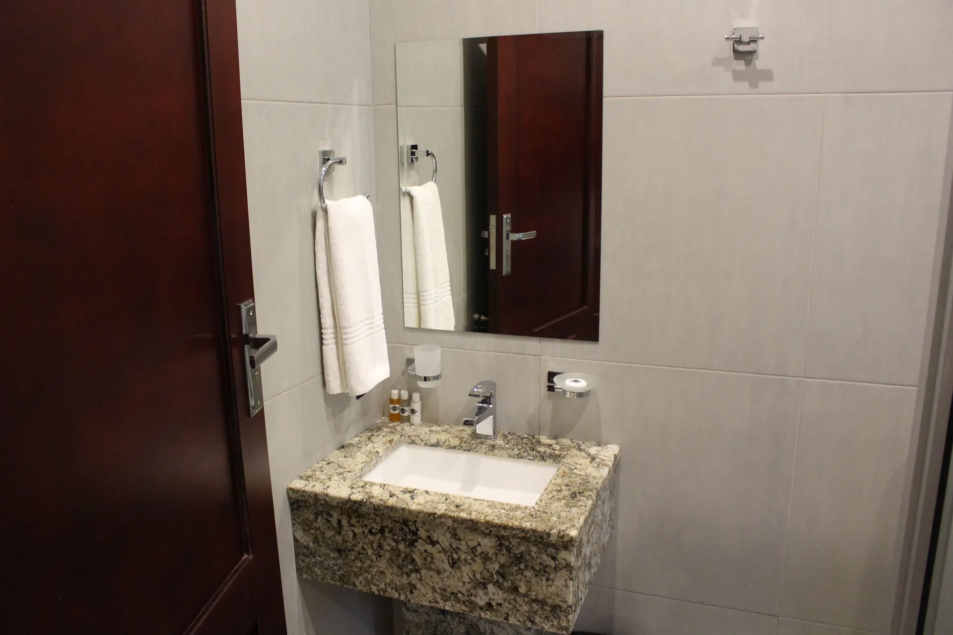 Granite vanity with mirror and fresh white towel in the Deluxe Room en-suite at FIRN Lodge