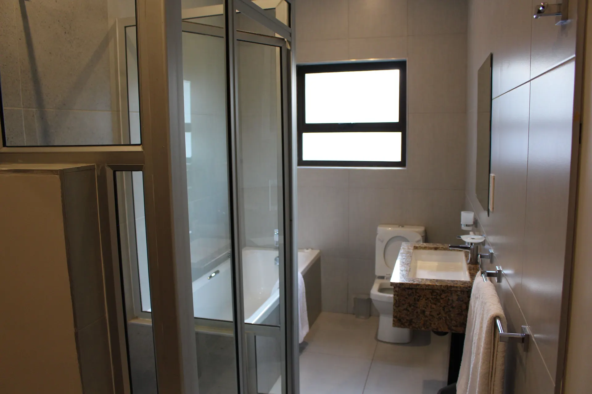 Executive Room bathroom at FIRN Lodge with a bathtub, separate glass shower and granite vanity