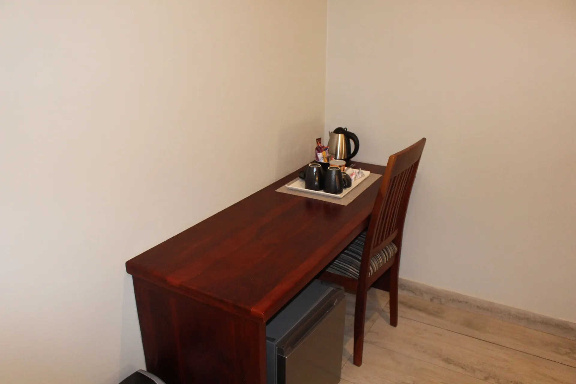 Wooden writing desk with tea and coffee station and mini fridge in the Executive Room at FIRN Lodge
