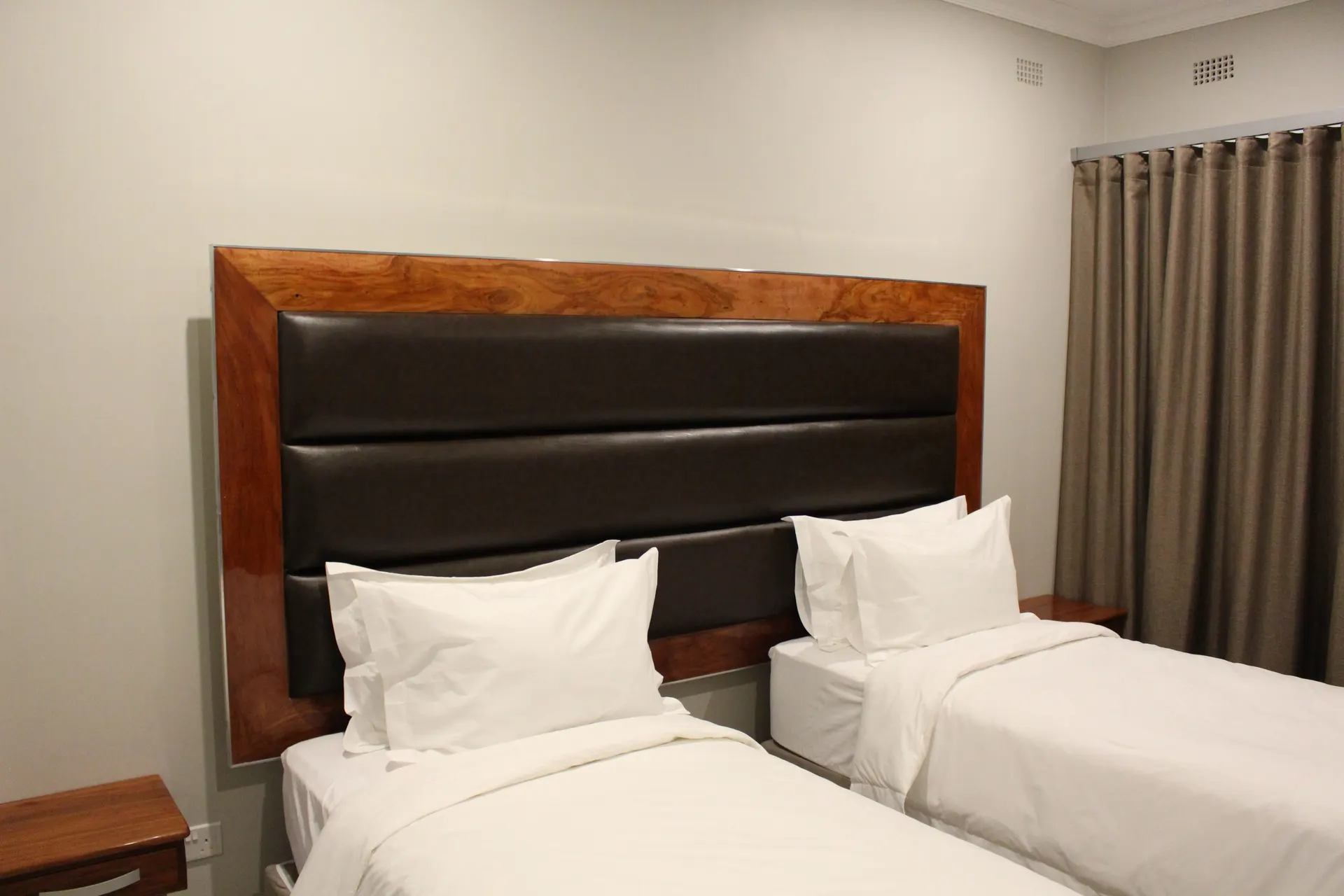 Poolside Twin Room at FIRN Lodge with two single beds under a shared leather headboard